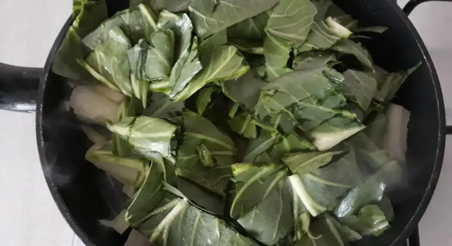 Verdure a coste in padella, che rilasciano vapore mentre cuociono.