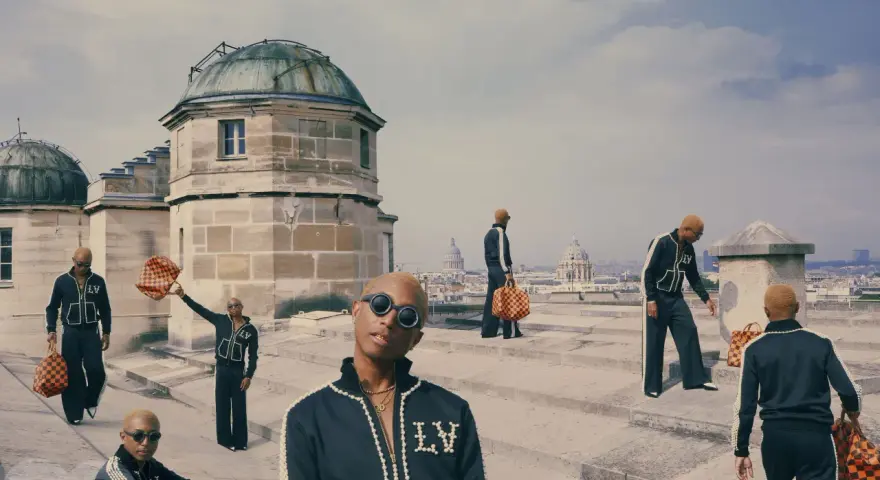 Uomini con tute Louis Vuitton e borse iconiche, un omaggio a chi era Louis Vuitton e al suo impero.