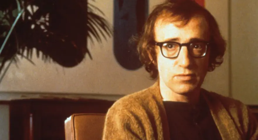 Woody Allen w okularach, w brązowym swetrze. Jego filmy chronologicznie to podróż przez dekady kina.