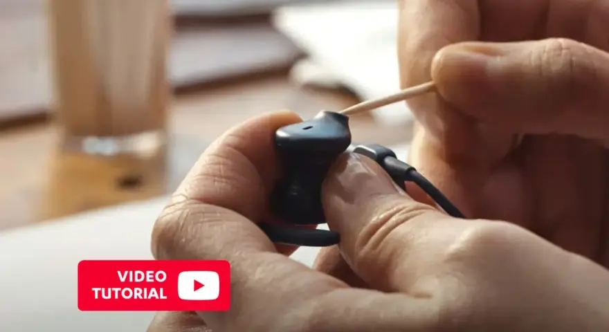 Pokazano, jak wyczyścić słuchawki douszne za pomocą wykałaczki. Wideo tutorial.