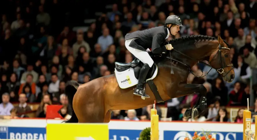 Le jeune cavalier Sandro, en plein saut d'obstacles, impressionne la foule.