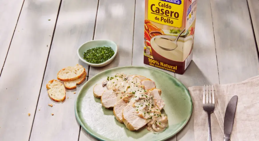Lonchas de solomillo de pavo con salsa cremosa de champiñones, acompañadas de pan tostado y cebollino picado.