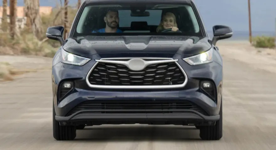 A couple in a dark SUV drive on a dirt road. They might be wondering how long to wait for jump start if the car dies.
