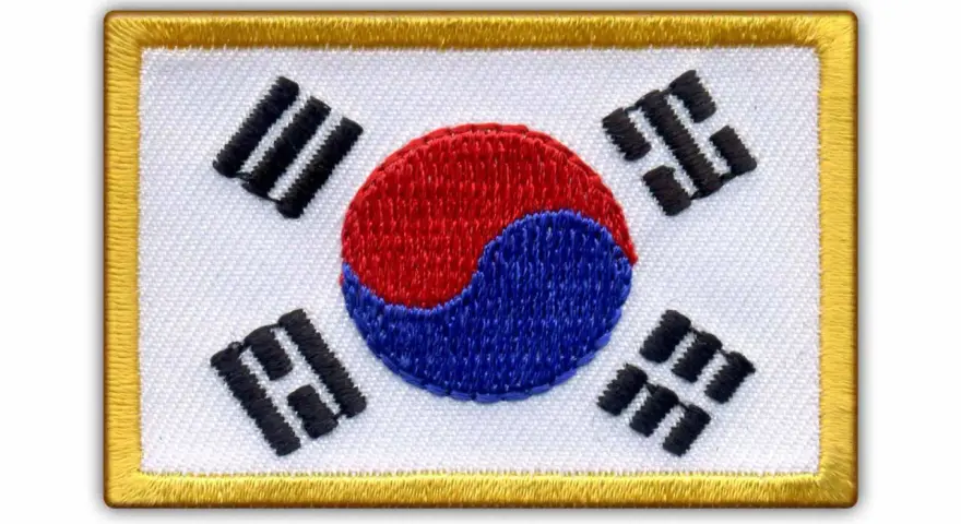Naszywka z flagą Korei Południowej. Białe tło, czerwono-niebieski symbol yin-yang i czarne trygramy.
