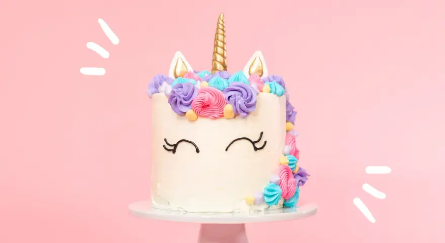 Magisk enhörningstårta med horn och öron, dekorerad med färgglad frosting. Ett perfekt unicorn tårta recept för kalaset!
