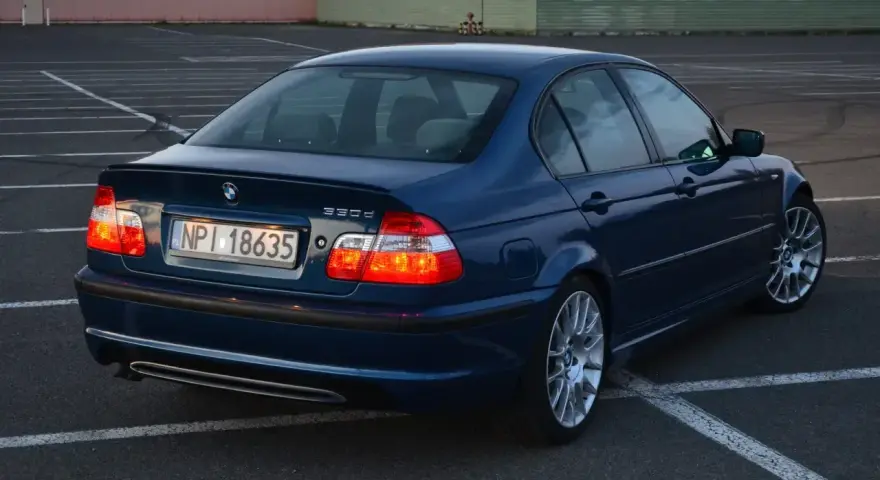 Niebieskie BMW E46 330d na parkingu. Wiele osób chwali ten model za osiągi i komfort.