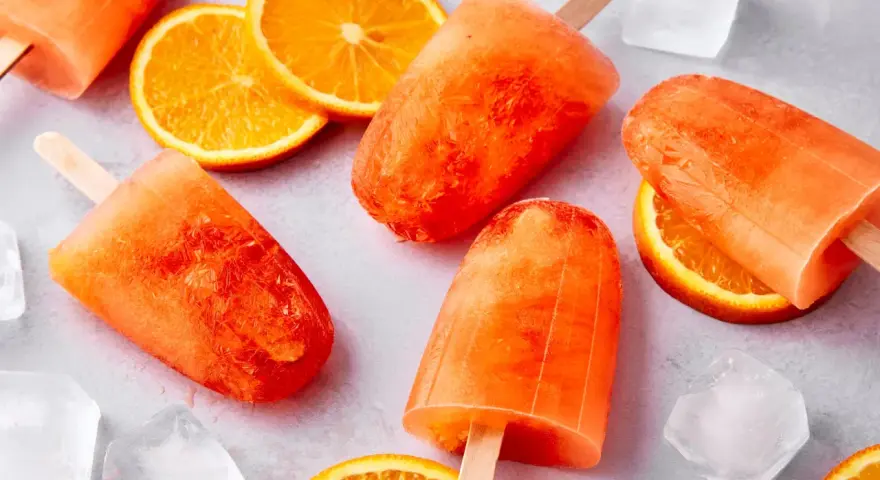 Erfrischendes Aperol Eis mit Orangenscheiben und Eiswürfeln. Perfekt für heiße Sommertage.