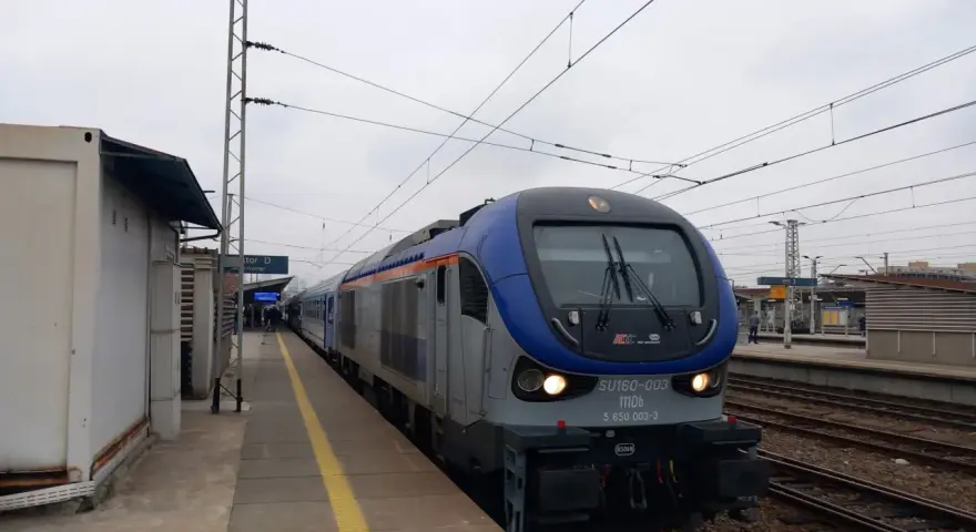 Lokomotywa PKP Intercity SU160-003 na torach kolejowych przy peronie.