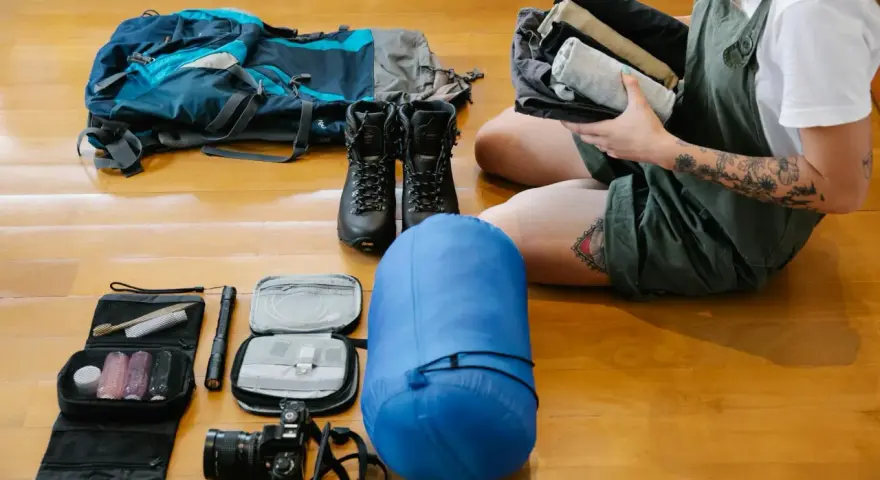 Plecak, buty trekkingowe, śpiwór, kosmetyczka, latarka, aparat i ubrania – to wszystko, co wziąć pod namiot na wyprawę.