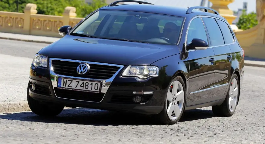 Czarny Volkswagen Passat B6 2.0 TDI 140KM na polskich tablicach rejestracyjnych WZ 74810, jadący po brukowanej drodze.