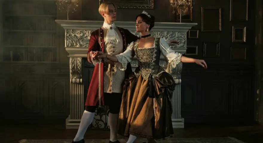 Pareja bailando en un salón elegante, como si estuvieran reviviendo la época de quien inventó el baile.