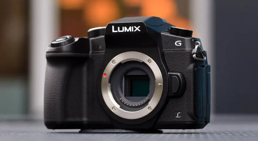 Czarny aparat Lumix G z widocznym mocowaniem obiektywu i migawką elektroniczną.