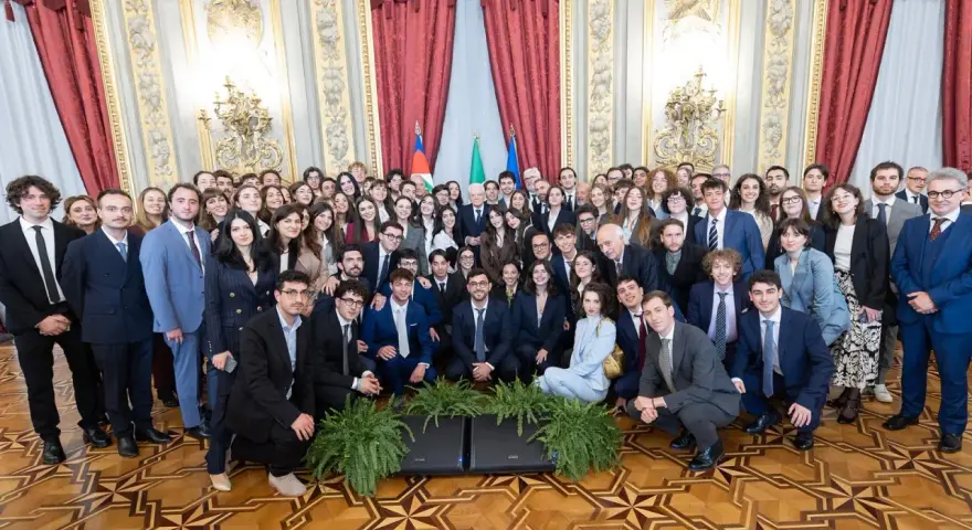 Un folto gruppo di giovani studenti posa per una foto di gruppo, forse dopo un evento alla scuola di giornalismo Roma.