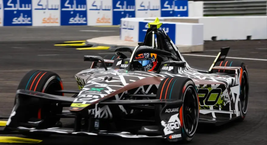 Coche de Fórmula E en Jarama, con diseño agresivo y colores vibrantes, listo para la carrera.