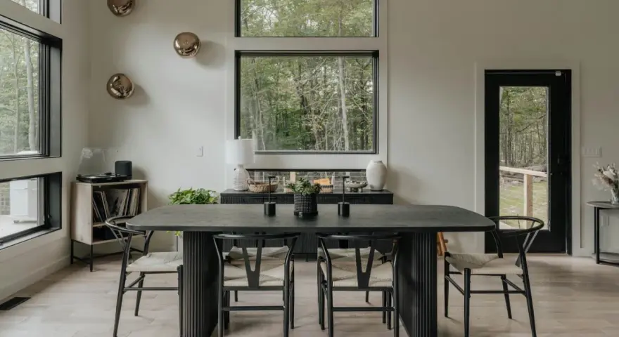 Elegante mesa negra y sillas de diseño para una perfecta decoracion comedores modernos. Ventanales con vistas al bosque.