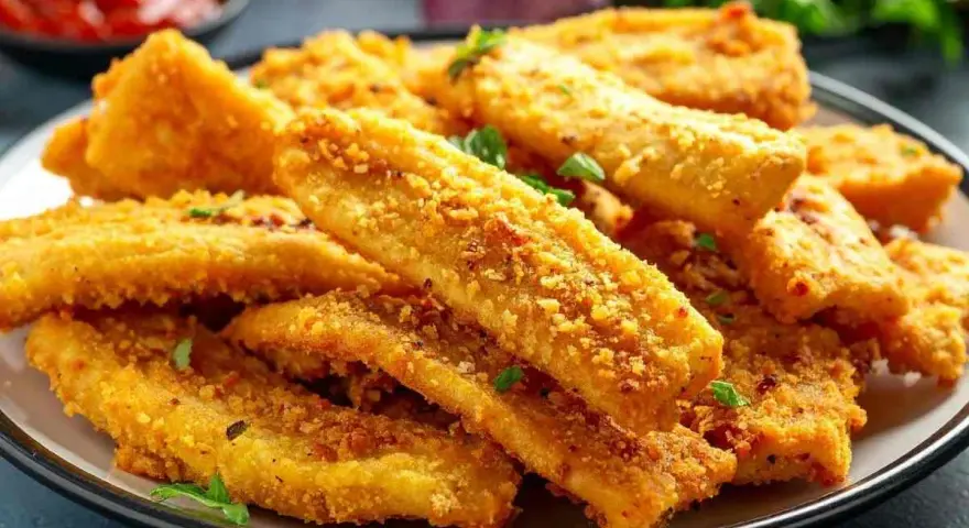 Bastoncini croccanti di zucchine in friggitrice ad aria, dorati e saporiti, guarniti con prezzemolo fresco.
