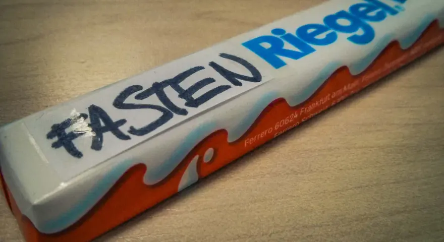 Ein Schokoriegel mit der Aufschrift "#FASTEN Riegel" – eine humorvolle Frage, was man in der Fastenzeit isst.