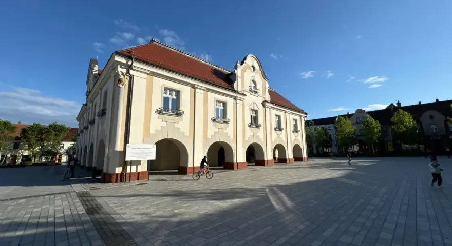 Ratusz w Jarocinie, plac z rowerzystą i dziećmi. Wiele się dzieje, to świetne jarocińskie wydarzenia!