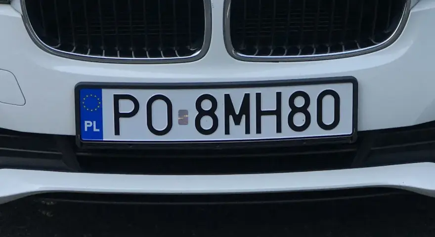 Białe BMW z tablicą rejestracyjną PO 8MH80.