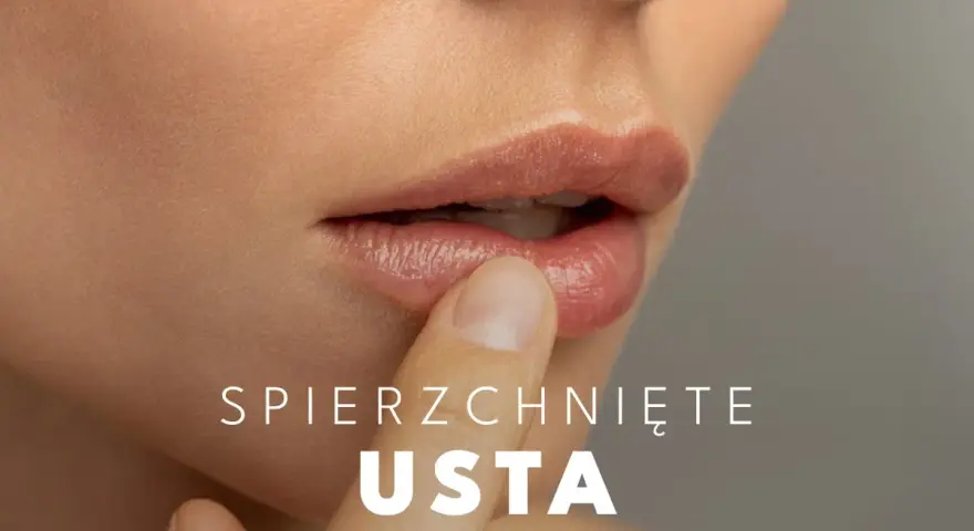 Delikatny dotyk palca na spierzchniętych ustach, szukając ulgi.