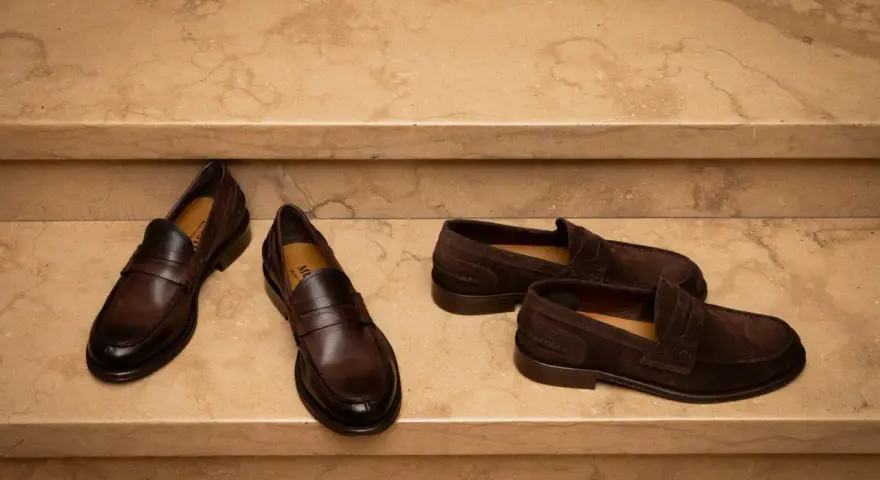 Due paia di mocassini uomo marroni, uno in pelle lucida e l'altro in camoscio, perfetti per un outfit elegante.