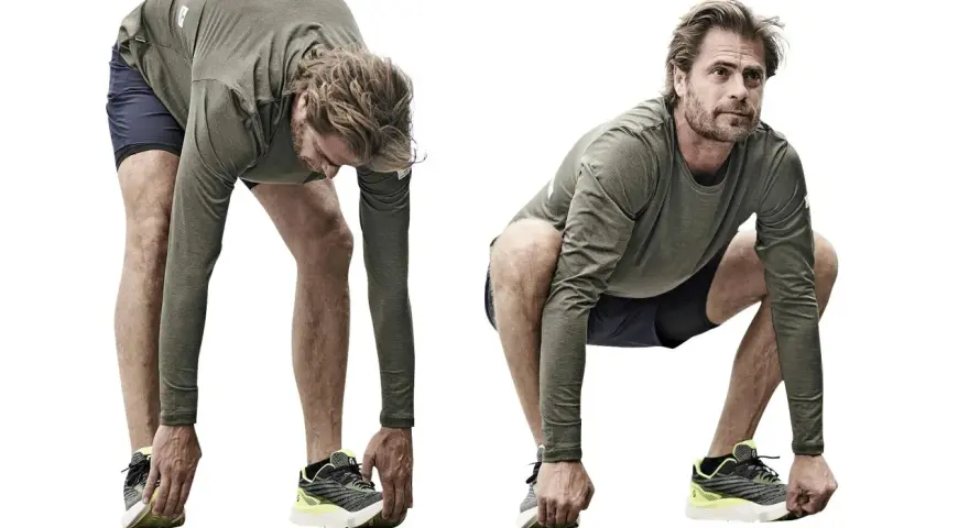 Man utför dynamisk stretching, böjer sig framåt med raka ben och rör vid skorna.
