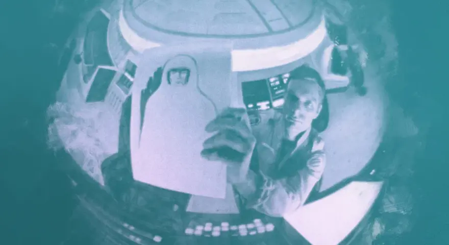 Inquadratura soggettiva: un astronauta in una navicella tiene in mano un disegno di sé stesso con casco.