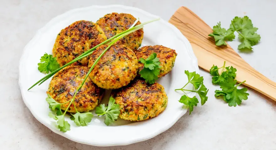 Goldbraune Hirse-Patties, garniert mit frischen Kräutern, sind ein köstliches Beispiel für Hirse Gerichte.