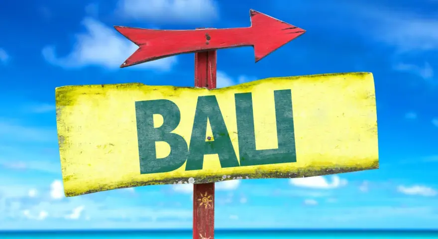 Strzałka kierunkowa wskazuje drogę do Bali. W tle błękitne niebo i morze.