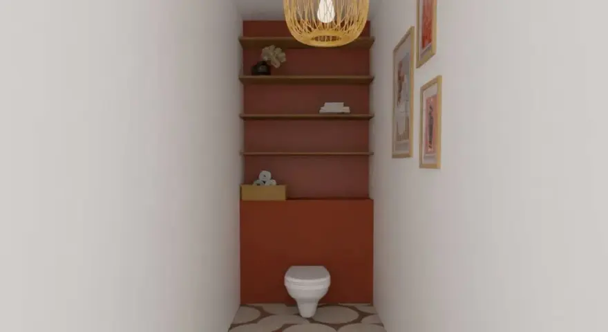 Un WC blanc est niché dans un alcôve aux murs rouge brique. Des étagères en bois flottent au-dessus, ornées d'objets décoratifs. Le sol est carrelé de cercles dans des tons terreux.