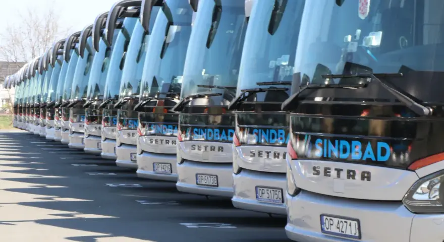 Rząd białych autokarów Sindbad Setra gotowych do podróży z Niemiec do Polski.