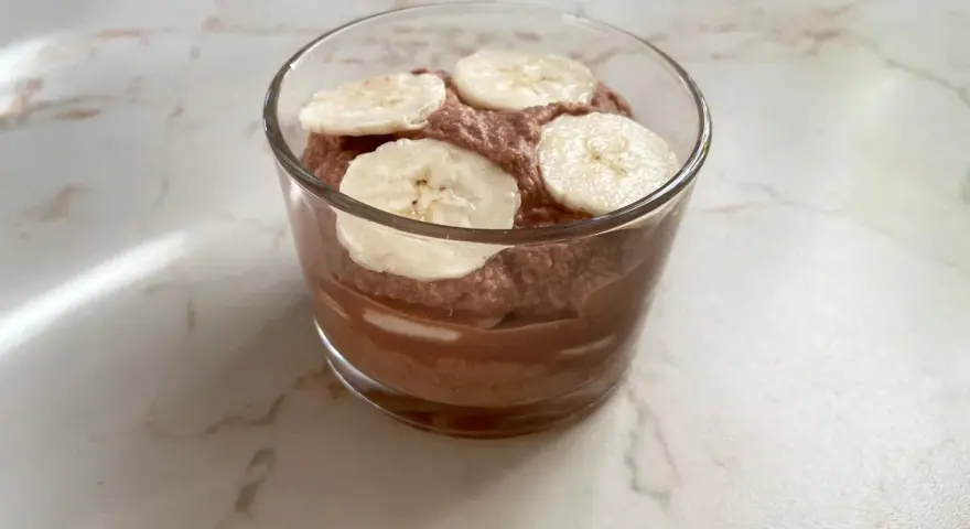 Schokoladiger Genuss: Ein Glas mit luftiger Nutella-Creme mit Mascarpone, garniert mit frischen Bananenscheiben.