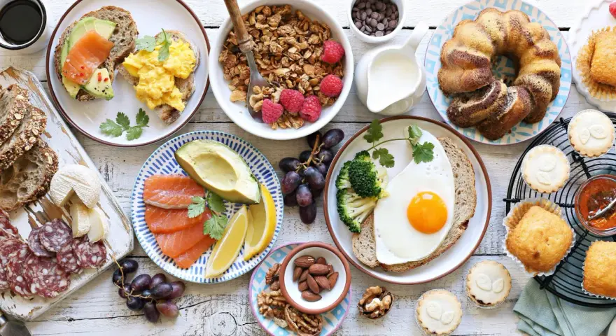 Leckeres Fingerfood für den Osterbrunch: Rührei, Lachs, Avocado, Kuchen, Muffins und Nüsse.