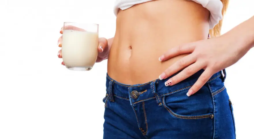 Donna con bicchiere di latte, un aiuto per sapere cosa bere la sera per andare di corpo.