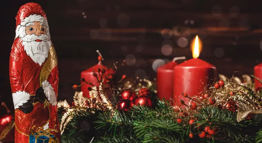 Schokoladen-Nikolaus und Adventskranz mit brennender Kerze. Der zweite Adventssonntag ist da!