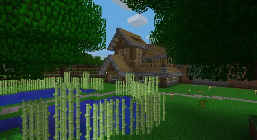 Drewniany dom z kamiennymi elementami, otoczony bambusami i wodą. W Minecraft można budować takie cuda i tworzyć własne światy.