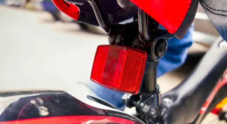 Catadiottri cosa sono? Questo è un riflettore rosso su una bicicletta, essenziale per la sicurezza.