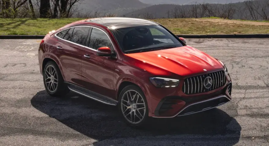 Czerwony Mercedes SUV, jeden z najnowszych mercedes suv modele, zaparkowany na tle górskiego krajobrazu.