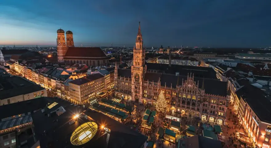 Beleuchtetes Rathaus und Christkindlmarkt in München, ein perfekter Ort für Munich Sightseeing bei Nacht.
