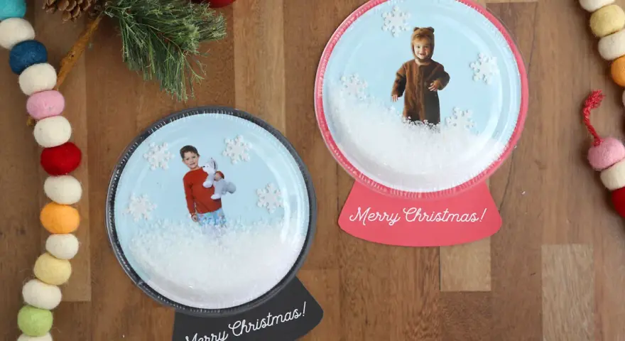 Dwie personalizowane kule śnieżne ze zdjęciami dzieci i płatkami śniegu.