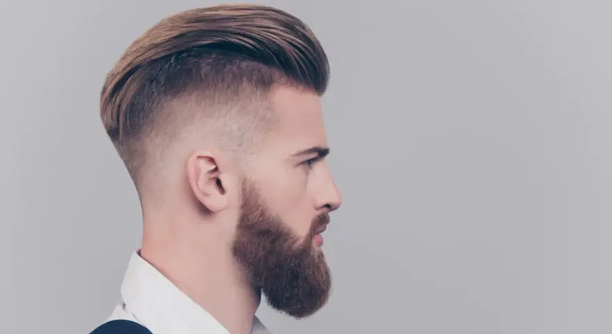Mężczyzna z modnym irokezem i zadbaną brodą, stylizacja na rockmana.