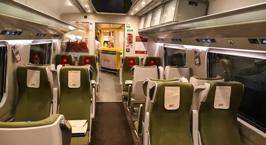 Wnętrze wagonu PKP Intercity. Puste zielone fotele czekają na pasażerów. Pamiętaj, że pkp intercity bilet bez gwarancji miejsca do siedzenia może oznaczać podróż na stojąco.