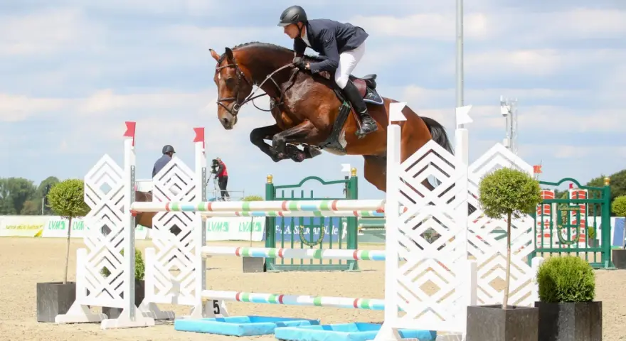 Un cavalier et son cheval, un étalon kannan, franchissent un obstacle lors d'une compétition d'équitation.