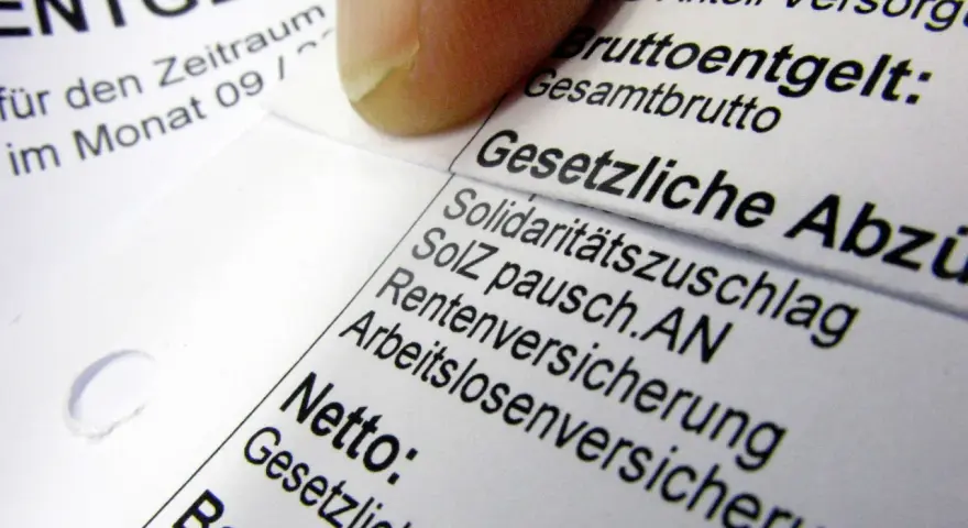 Finger auf Lohnabrechnung, die "Gesetzliche Abzüge" zeigt. Hier wird die Bedeutung der Kirchensteuer lfd. erläutert.