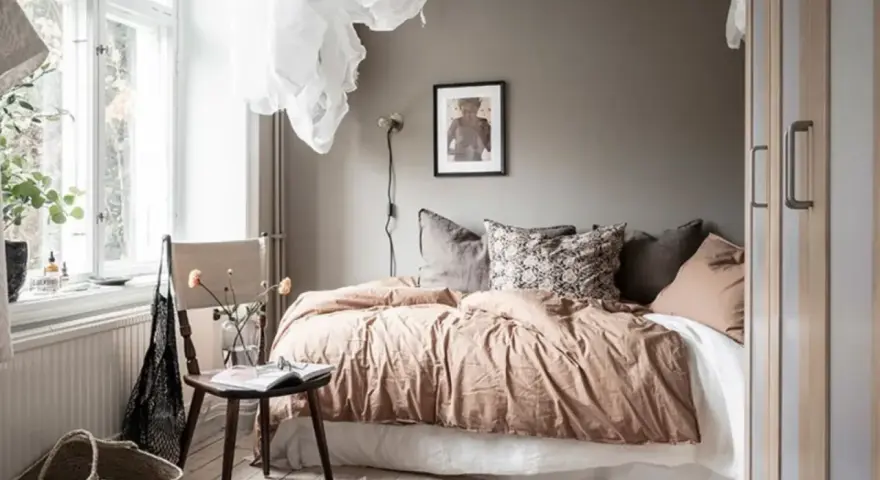 Camera da letto in **stile nordico**, con letto accogliente, tessuti naturali e un tappeto decorativo. L'ambiente evoca un **stile norvegese** rilassante.
