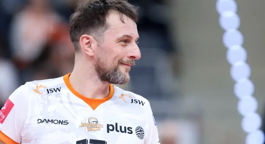 Uśmiechnięty rozgrywający w siatkówce, z numerem 17 na koszulce, gotowy do gry.