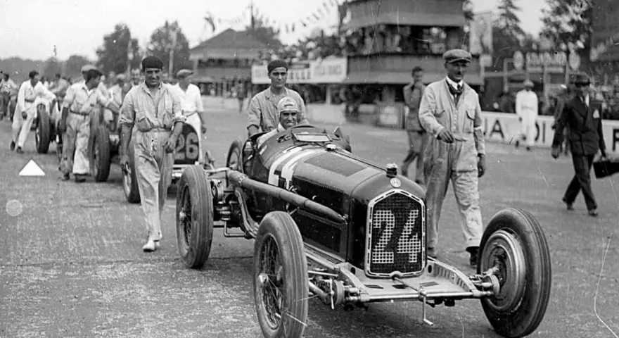 Tazio Nuvolari, leggenda dell'automobilismo, con la sua Alfa Romeo numero 24, pronto a sfrecciare.