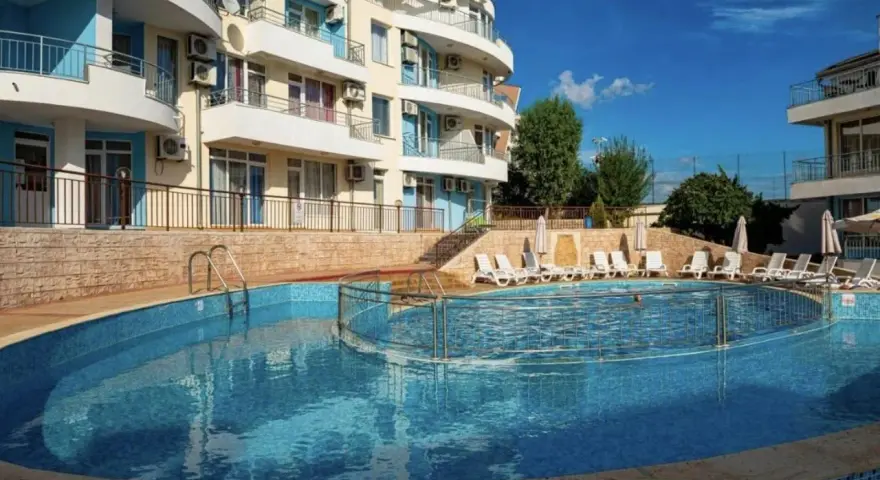 Słoneczna plaża w Bułgarii: basen z leżakami i hotel w tle, idealne miejsce na wakacje.