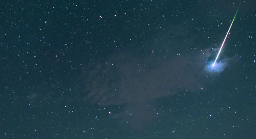 Ein leuchtender Schweif zieht sich durch den sternenklaren Nachthimmel, ein Zeichen für die magischen sternschnuppen.