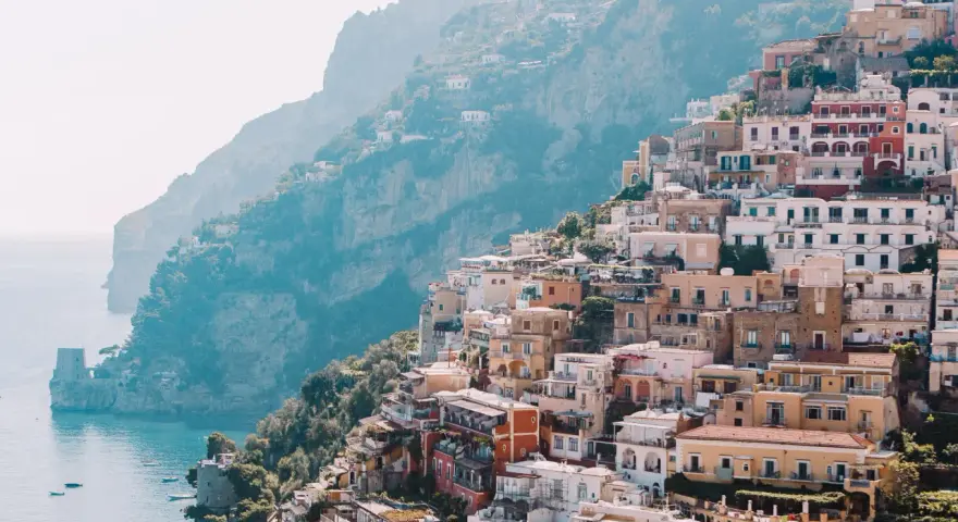 Colorful buildings cascade down a cliffside to the sea, a picturesque scene perfect for a 3 month Europe itinerary.